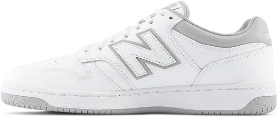 Witte lage sneaker met grijze New Balance 'N' logo's op de zijkant en grijze accenten.