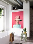 Audrey Hepburn portant un grand chapeau, un nœud rose et un haut bleu pâle, sur fond rose, dans une salle de bain près d'une baignoire.