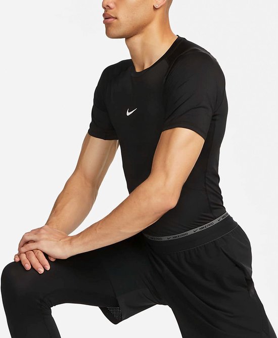 Man met zwarte Nike Pro top, korte mouwen en grijze band met 'NIKE PRO' op de shorts.