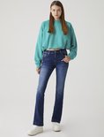 Een model draagt een donkerblauwe flared jeans en een cropped turquoise hoodie.