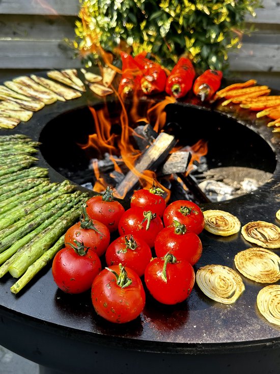 Groenten en tomaten op een grill met vlammen.
