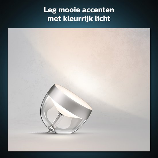 Zilverkleurige Philips Hue Iris tafellamp met glazen kap, die gekleurd licht uitstraalt.