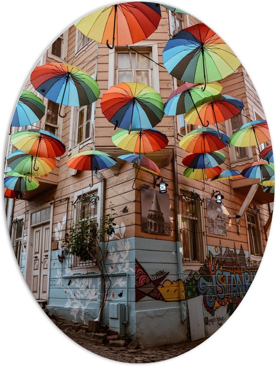 PVC Schuimplaat Ovaal - Plafond van Kleurrijke Paraplu's in Dorpssystraat - 60x80 cm Foto op Ovaal (Met Ophangsysteem)