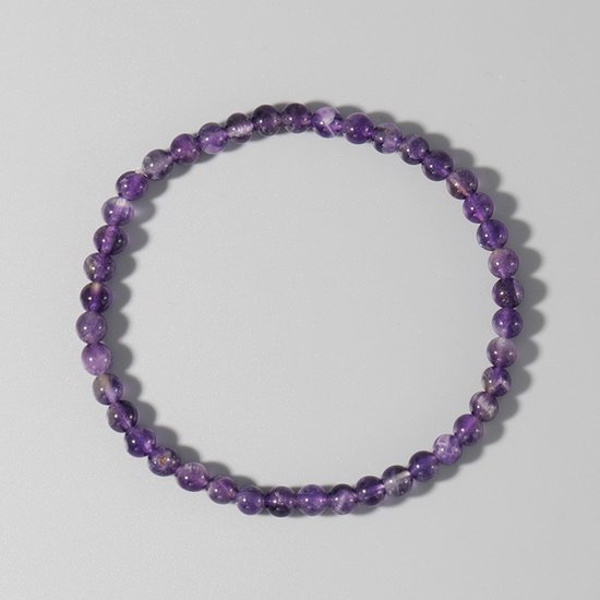 Dunne armband van paarse amethistkralen met lichte variaties in kleur.