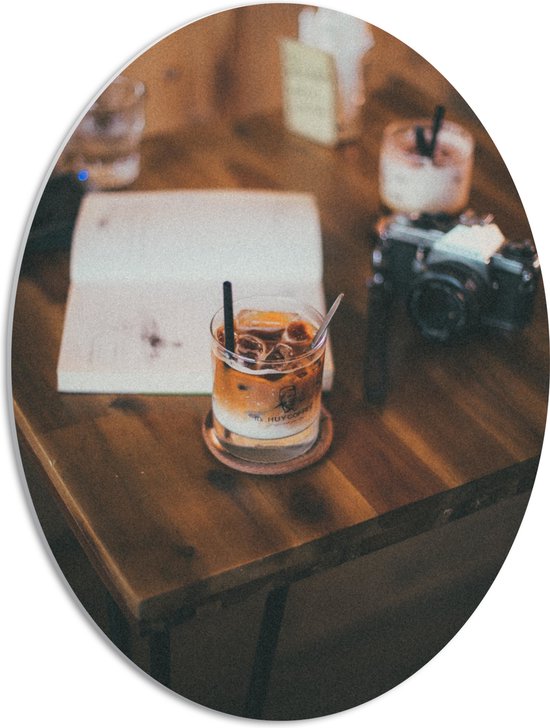 PVC Schuimplaat Ovaal - Tafel met Koffie, Boek en een Camera - 42x56 cm Foto op Ovaal (Met Ophangsysteem)