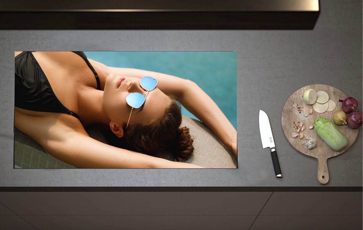 Inductieplaat Beschermer - Vrouw in Zwarte Bikini Liggend op Zwembadrand - 90x52 cm - 2 mm Dik - Inductie Beschermer van Vinyl