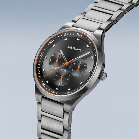 Bering herenhorloge met grijze wijzerplaat, zilverkleurige band en oranje accenten.