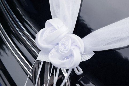 Twee witte satijnen rozen met organza lint voor autodecoratie.