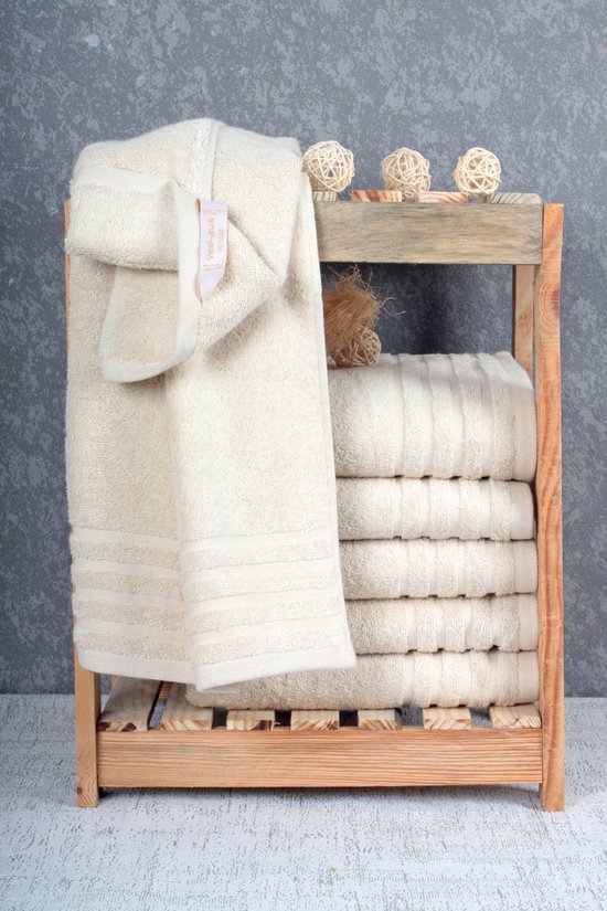 Beige Betully handdoeken op een houten rek, met decoratie.