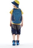 Jongen met gele hoed en rugzak, staand met de rug naar de camera. De rugzak is blauw met een geometrisch patroon.