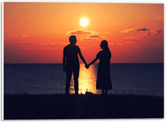 PVC Schuimplaat- Silhouet van Koppel Hand in Hand bij de Zee tijdens Zonsondergang - 40x30 cm Foto op PVC Schuimplaat