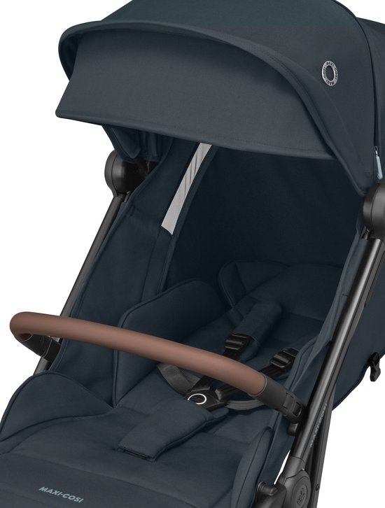 Close-up van de zitting van de donkerblauwe Maxi-Cosi kinderwagen met bruine beugel en veiligheidsharnas.