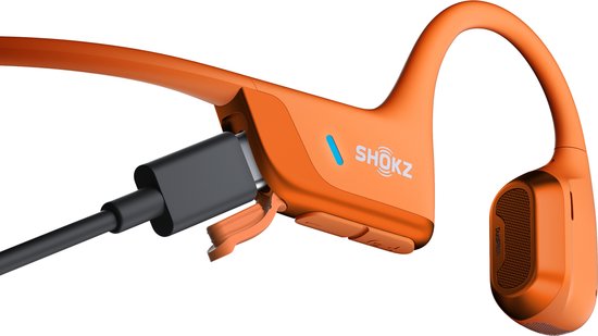 Oranje Shokz OpenRun Pro 2 koptelefoon met USB-C kabel aangesloten.