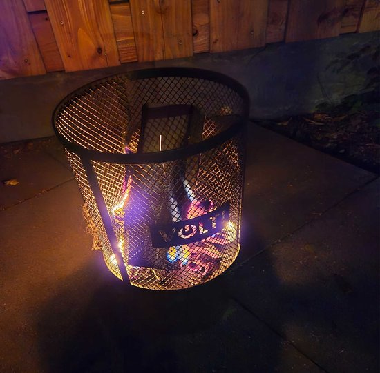 Brandende zwarte metalen vuurkorf met VOLT! logo, op een betegeld terras.