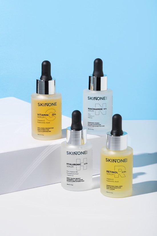 Vier SKINTONE serumflessen: vitamine C 20%, niacinamide 10%, hyaluronzuur 2,5% en retinoïden 2,5%. Geel, wit en transparant.