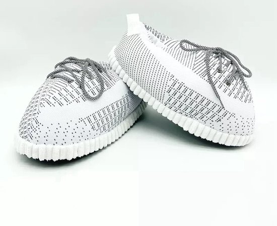 Paar witte sneaker sloffen met grijs gebreid patroon en veters.