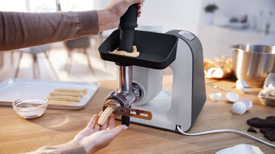 Robot de cuisine argenté-gris avec accessoire presse à biscuits, faisant des churros.
