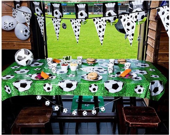 Een gedekte tafel met voetbalthema, compleet met ballonnen, slingers en servies.