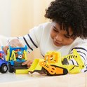 Jongen speelt met een blauwe kiepwagen en een gele graafmachine.