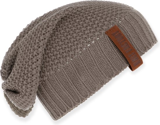Bruine gebreide beanie muts met een leren label.