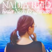 Pochette d'album 'Nadia Reid - Enter Now Brightness' avec une femme de dos, lunettes et queue de cheval. Fond coloré.