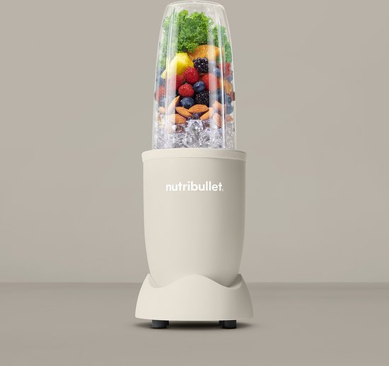 Linnen beige Nutribullet met beker vol ijs, bosbessen, bramen, aardbeien, sinaasappel, citroen en groenten.