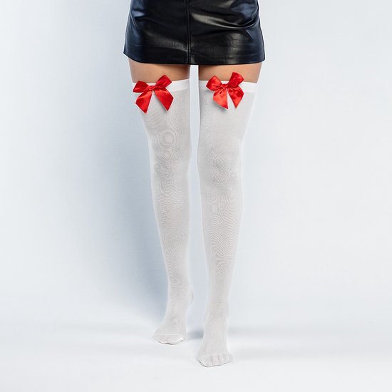 Witte dijhoge kousen met rode strikken, gedragen met een zwarte rok.