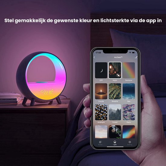 Witte ronde wekker met veelkleurige verlichting, naast een smartphone die bediend wordt via een app met nacht- en regenboogthema's.