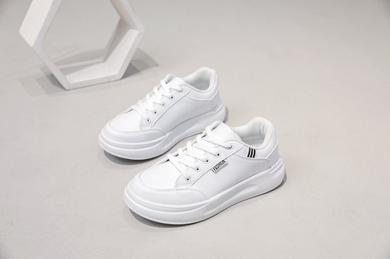 Witte lage sneakers met veters en een dikke zool. Tekst 'Fashion' op de zijkant.
