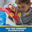 Een jongen drukt op de rode knop van de PAW Patrol Patroller voor spannende geluidseffecten. Ryder zit in de cabine.