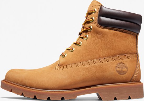 Botte lacée Timberland dorée avec col marron et lacets jaunes à accents rouges. Logo Timberland visible sur le côté.