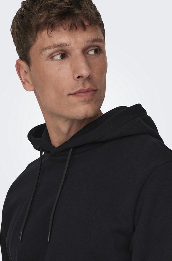 Close-up van de voorkant van een zwarte hoodie, met capuchon en trekkoorden.
