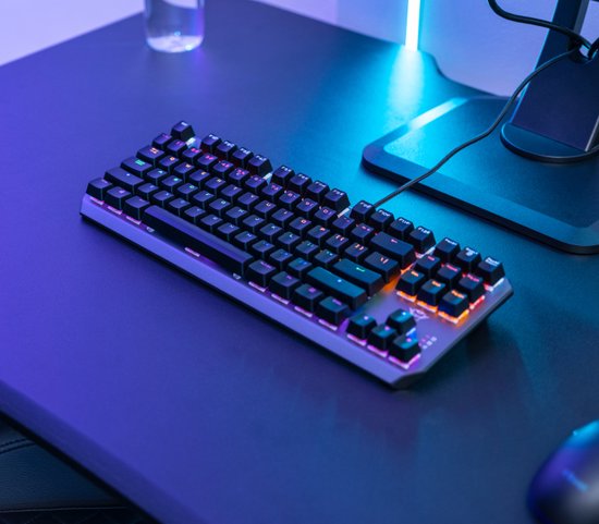 Zwart gaming toetsenbord met multicolour verlichting op een bureau.
