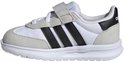 Witte kindersneaker met lichte grijze suède accenten, zwarte Adidas-strepen en klittenbandsluiting.