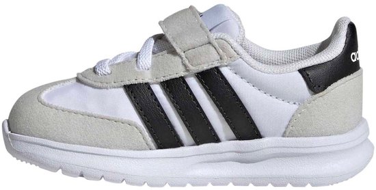 Witte kindersneaker met lichte grijze suède accenten, zwarte Adidas-strepen en klittenbandsluiting.