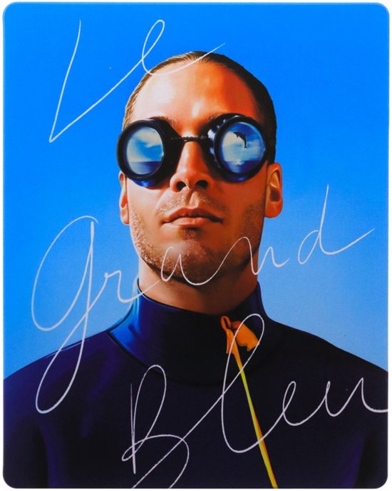 Een man met een duikbril en blauw wetsuit, met handtekening 'Le Grand Bleu'.