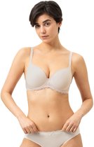 Modèle vu de face, portant un soutien-gorge armatures beige à bordures en dentelle et une culotte assortie.