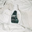 Witte fles wasmiddel op witte kleding.