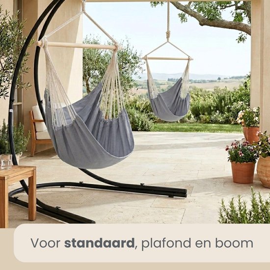 Een grijze hangstoel aan een frame en een blauwgrijze hangstoel aan een boom.