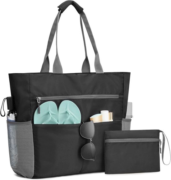 Zwarte strandtas met grijze handvatten en mesh zijvakken. Het hoofdcompartiment is open met teenslippers en flesjes, en een apart tasje.