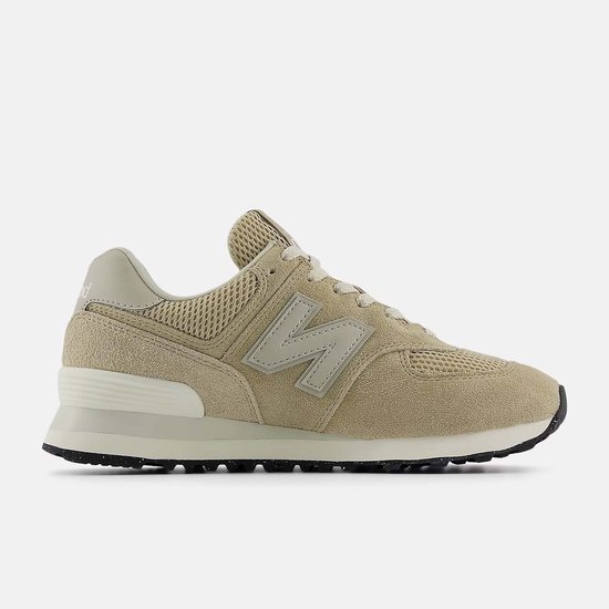 Zijaanzicht van een beige New Balance 574 sneaker met beige suède, mesh en 'N' logo.
