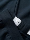 Sluiting van elastische tailleband met knopen, deel van een donkerblauwe joggingbroek.
