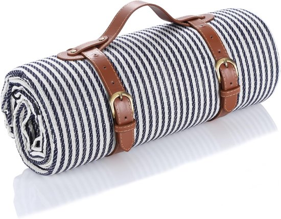Une couverture de pique-nique enroulée à rayures bleues et blanches, avec des sangles en cuir marron à boucles et une poignée.