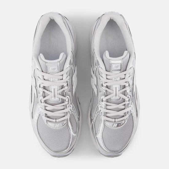 Bovenaanzicht van twee lichtgrijze New Balance 740 sneakers met metallic zilveren accenten.