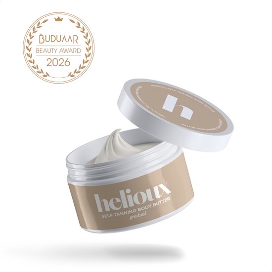 Helioux zelfbruiner body butter in een beige pot met witte deksel. De textuur is romig en lichtgeel. Gouden medaille 'BUDUAR BEAUTY AWARD 2026'.