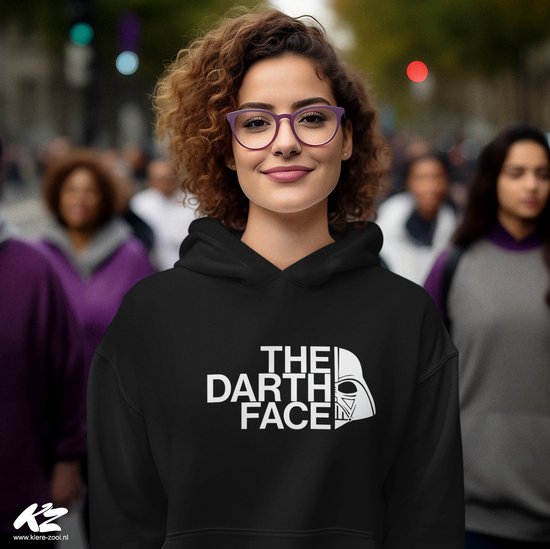 Zwarte hoodie met witte 'The Darth Face' print op de borst. Model draagt paarse bril en heeft krullend bruin haar.