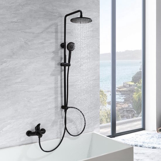 Ensemble de douche noir avec pomme de douche ronde et douchette, installé au-dessus d'une baignoire avec vue sur la mer.