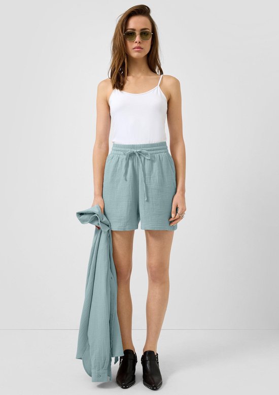 Model met lichtblauwe katoenen short met kreukelstof, trekkoord en witte top.