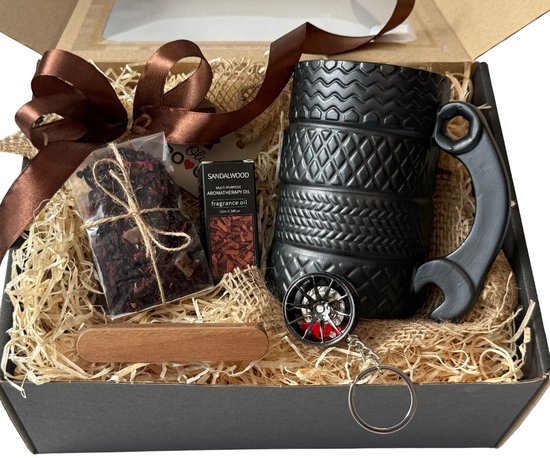 Zwarte geschenkdoos gevuld met mok met autobandprofiel, thee, sandalwood olie en sleutelhanger.