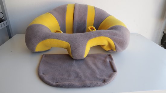 Babyzitje met grijze en gele strepen, met een apart grijs kleed.